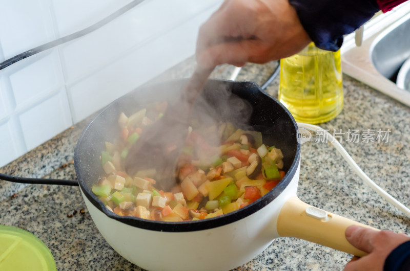 在电锅里炒菜