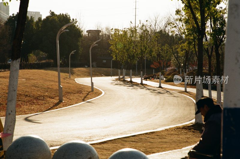 林间小路有人休憩的冬日公园景象