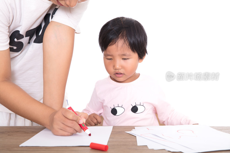 教老师在认真的辅导小女孩画画