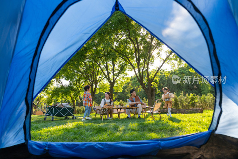 透过帐篷一家四口在露营地开心玩耍