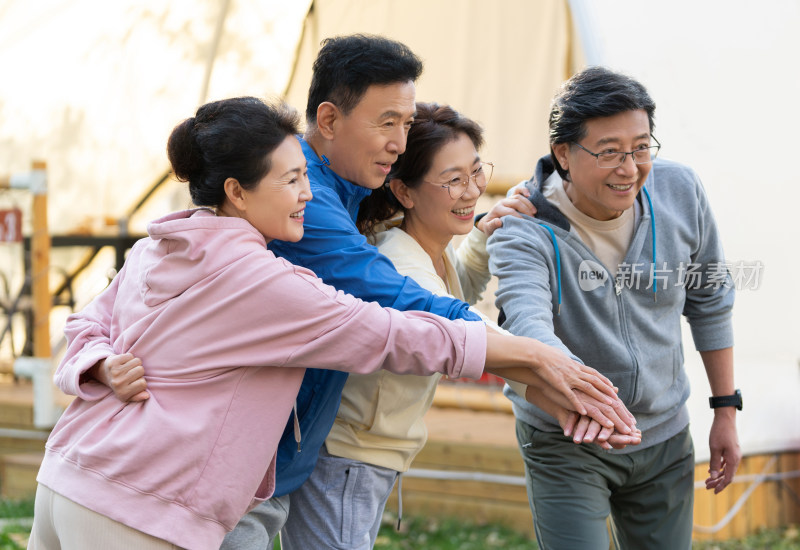 一群穿运动服的中老年人组成手堆