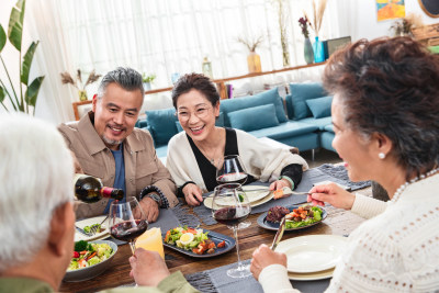 聚餐时中年男士给朋友倒红酒