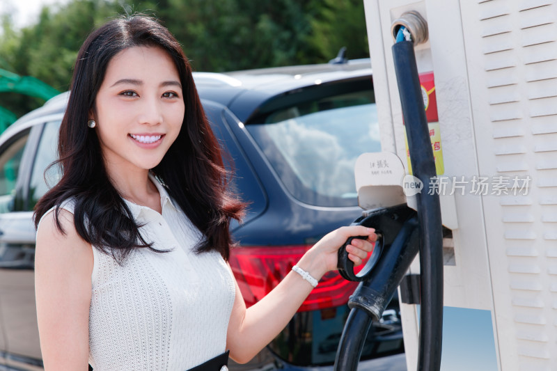 从充电桩取充电枪的青年女人