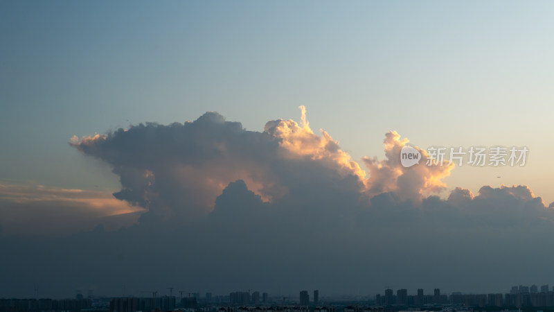 城市上空被霞光映照的壮观云层