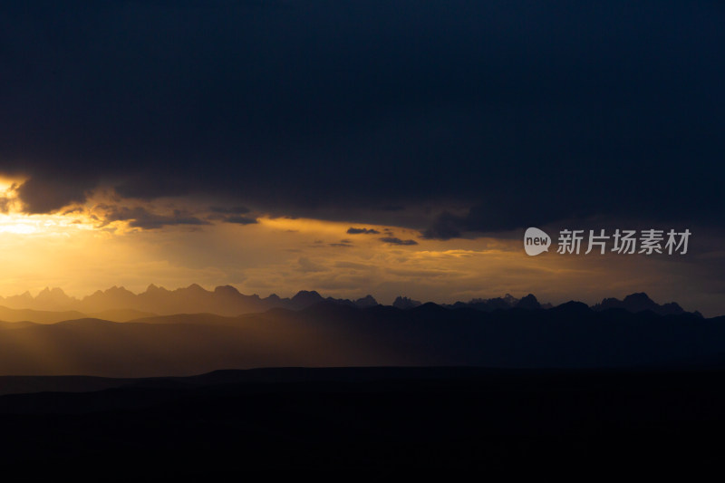 山峰日落时天空映衬的剪影景观