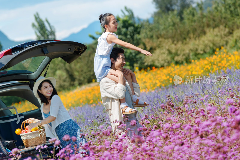 快乐的一家三口走在花海里