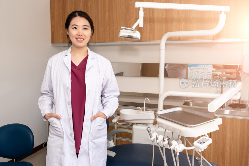 站在牙科治疗室的中国女性牙医