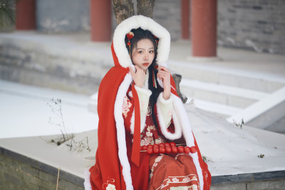 雪天户外身穿中式红色汉服的亚洲少女