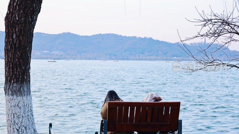 两人湖边长椅休憩赏景