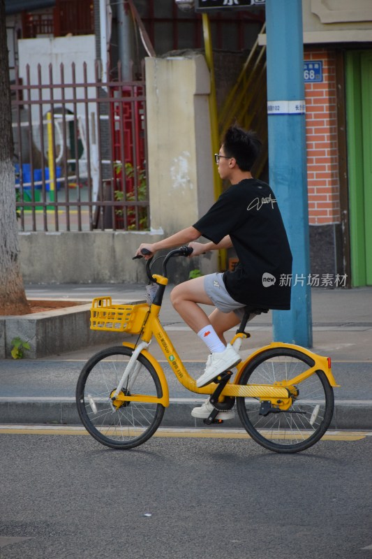 男子骑行黄色共享单车