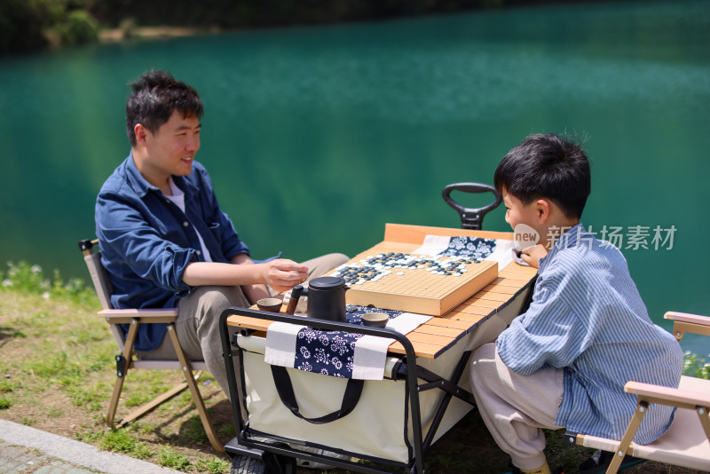 在湖边下围棋的父子