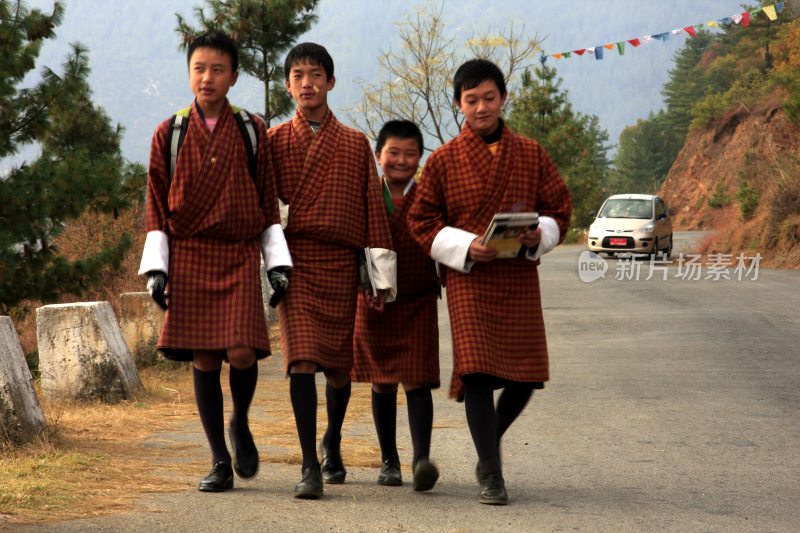 身着不丹传统服饰的少年结伴走在上学路上