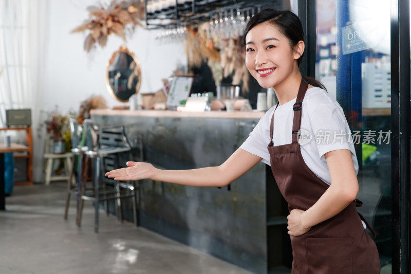 咖啡店门口迎接顾客的女服务员