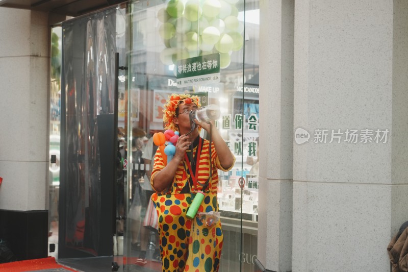 站在城市街道上拿着饮料扮成小丑的人在喝水