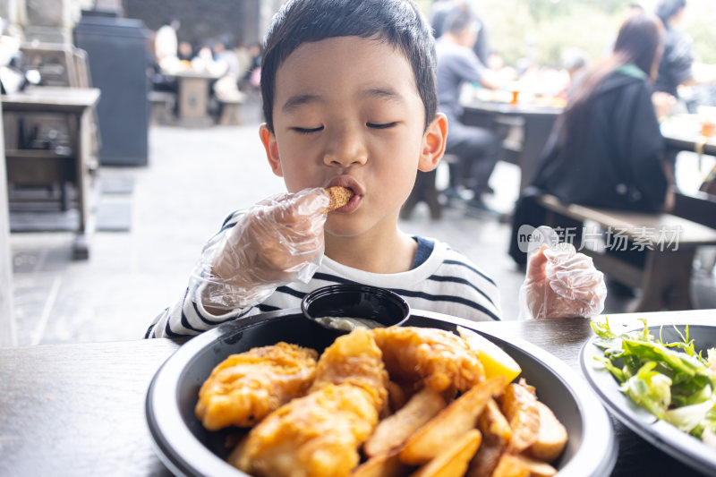小男孩满足地吃炸鸡薯条