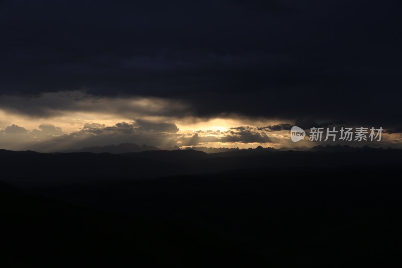 山峰日落时天空映衬的剪影景观