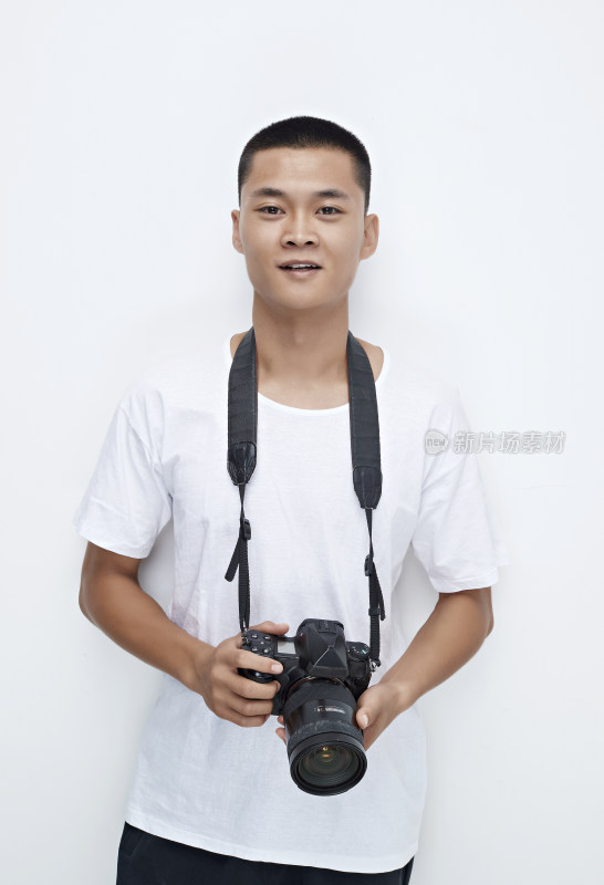 白色背景下手持照相机的亚洲男性摄影师