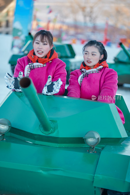 在冰天雪地玩耍雪上娱乐载具车辆的闺蜜少女