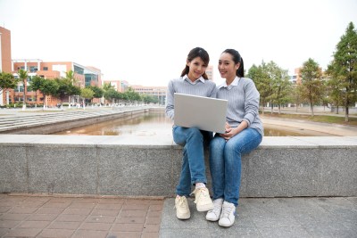 年轻大学生在校园里使用笔记本电脑