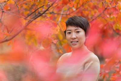 北京秋天站在枫树林中欣赏秋色美景的女性