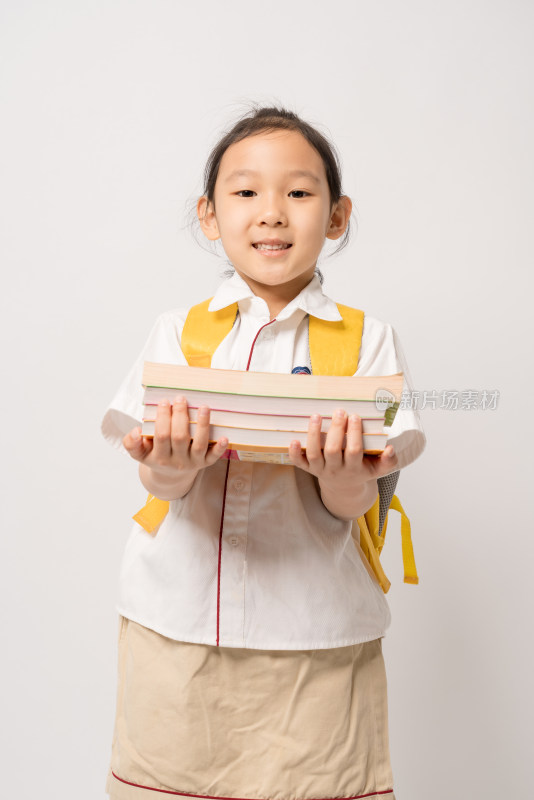 白色背景前怀抱书籍的中国女孩