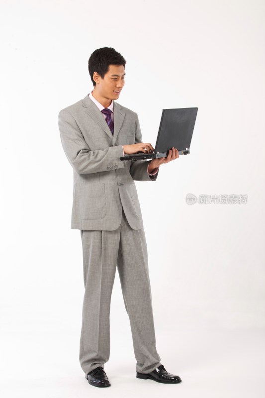商务男士抱着笔记本电脑