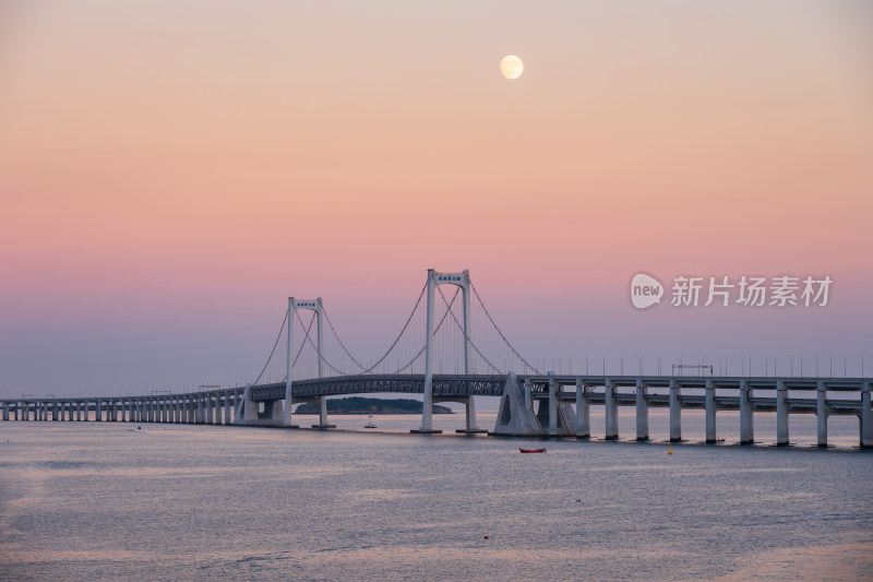 夕阳下大连星海湾大桥上空升起的月亮