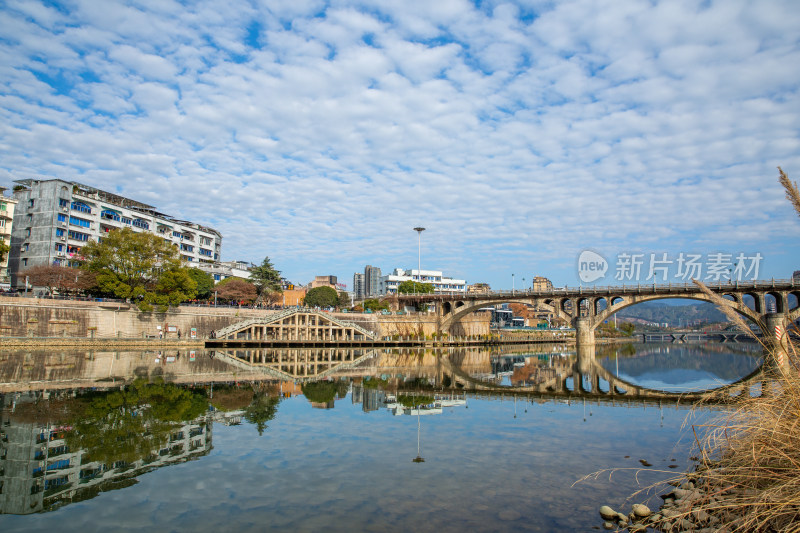 水域上石桥与岸边建筑倒影的景象