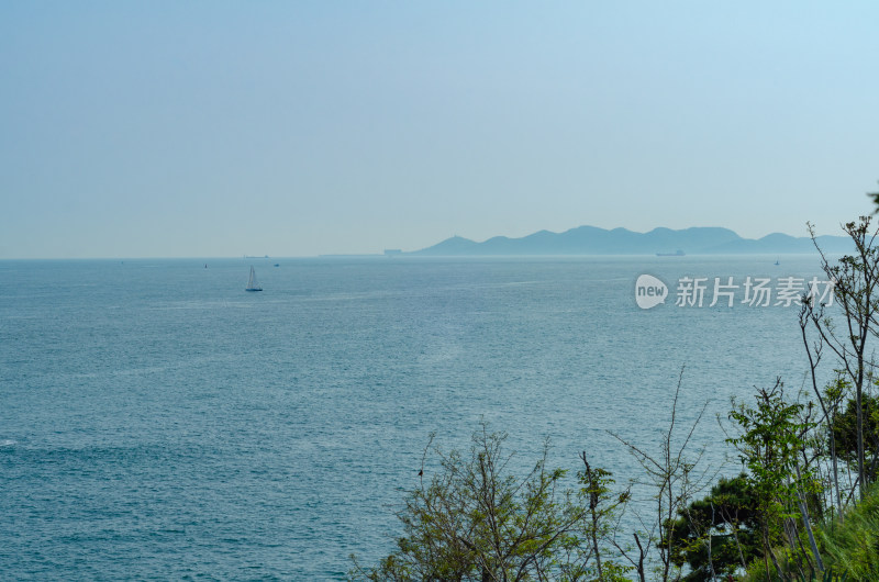 海上远景图，辽阔海面帆船与远山相映