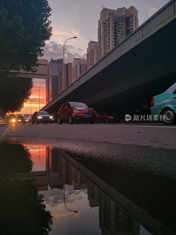 城市道路黄昏景，车辆行驶映倒影