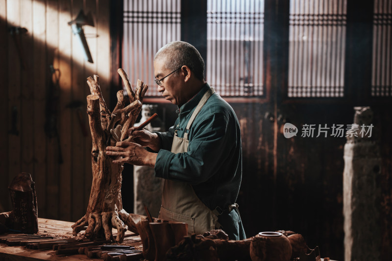 在树根上认真雕刻的工匠师