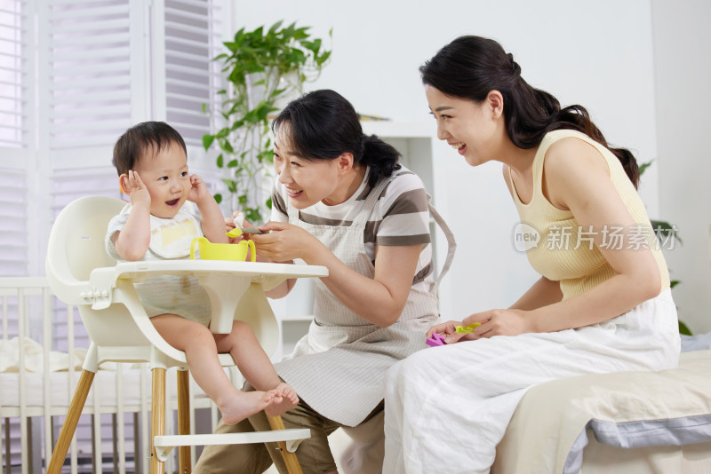 月嫂和年轻妈妈一起喂宝宝吃饭