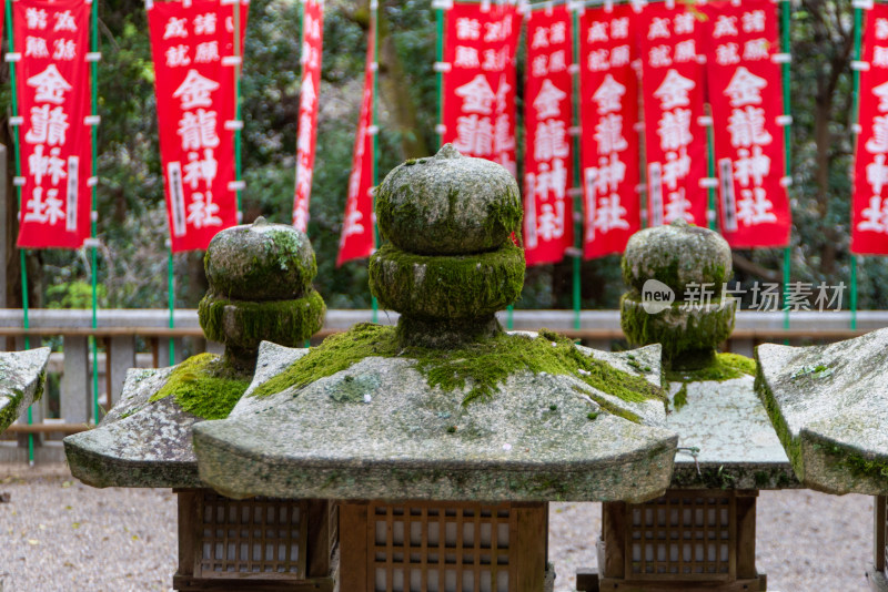 长满青苔的石制灯柱和红色旗帜