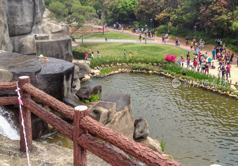 公园池塘边人群休闲场景