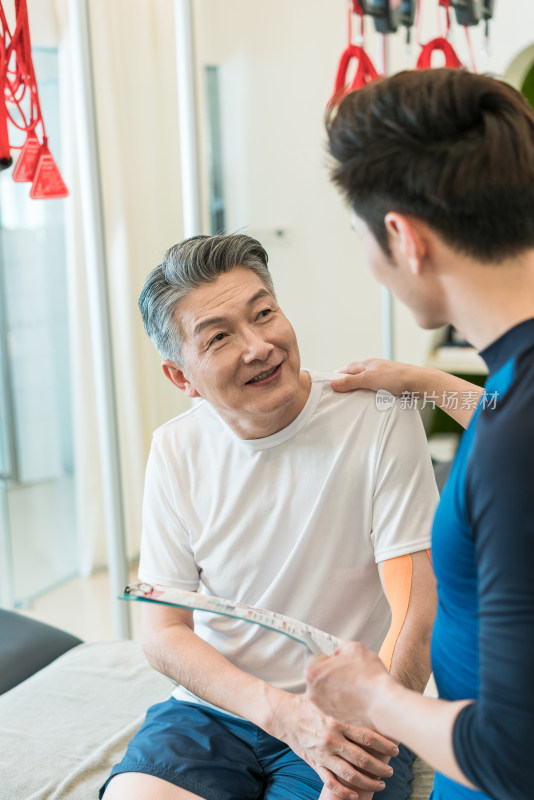 老年男子在私教的指导下健身