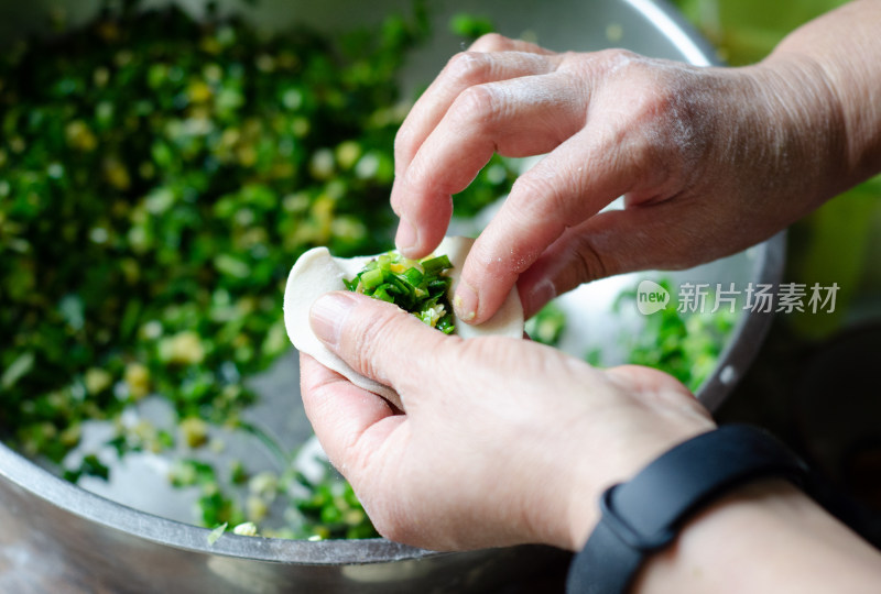 正在包韭菜鸡蛋饺子的女人的手特写