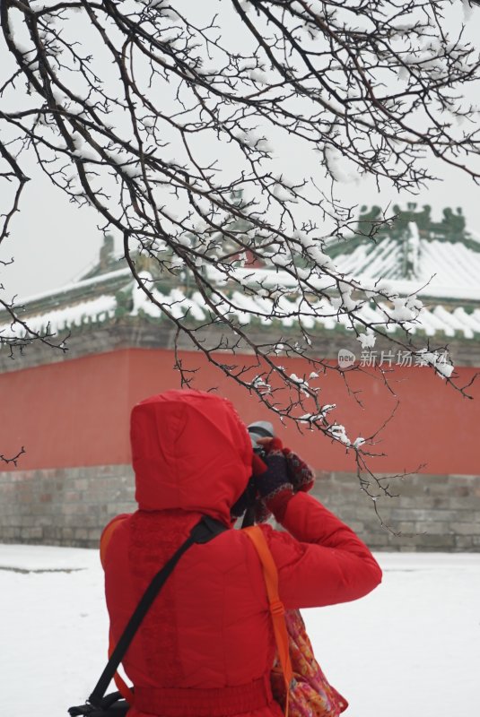 红衣人雪中拍摄古建筑