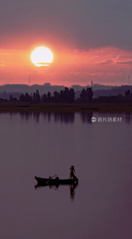 夕阳下湖面小船渔夫剪影