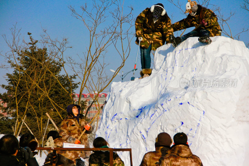 在哈尔滨人们户外合作制作大型雪雕