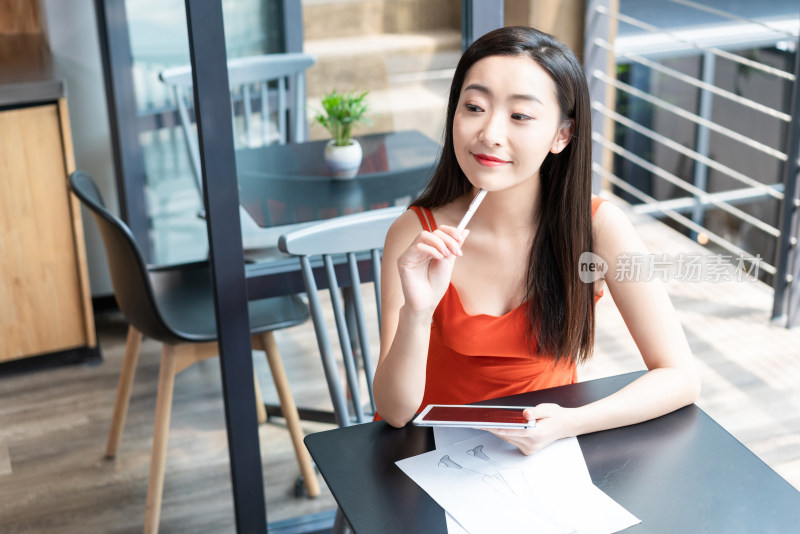 年轻女子看咖啡店使用平板电脑