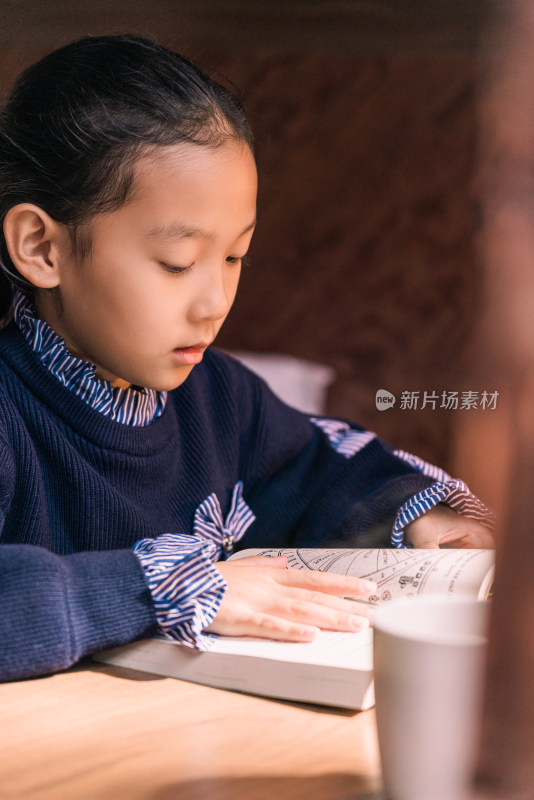 坐在房间内认真看书的中国女孩