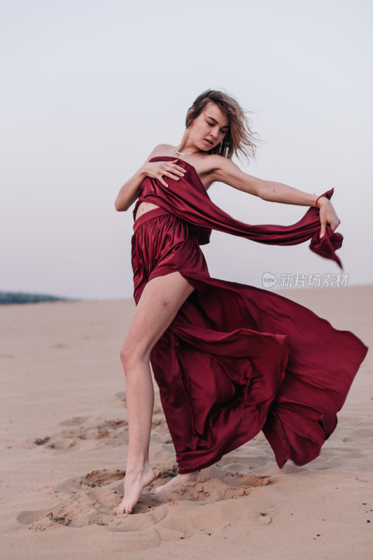 女子在沙漠身着红裙起舞