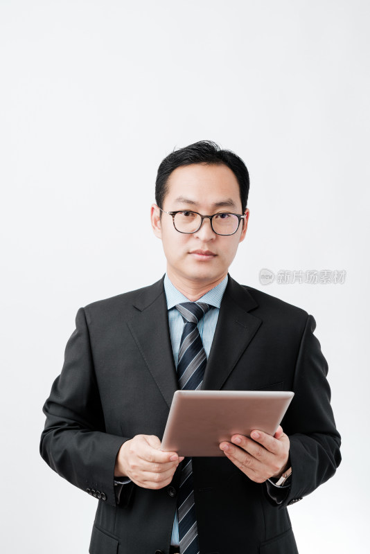 白色背景前穿西服使用平板电脑的亚洲男士