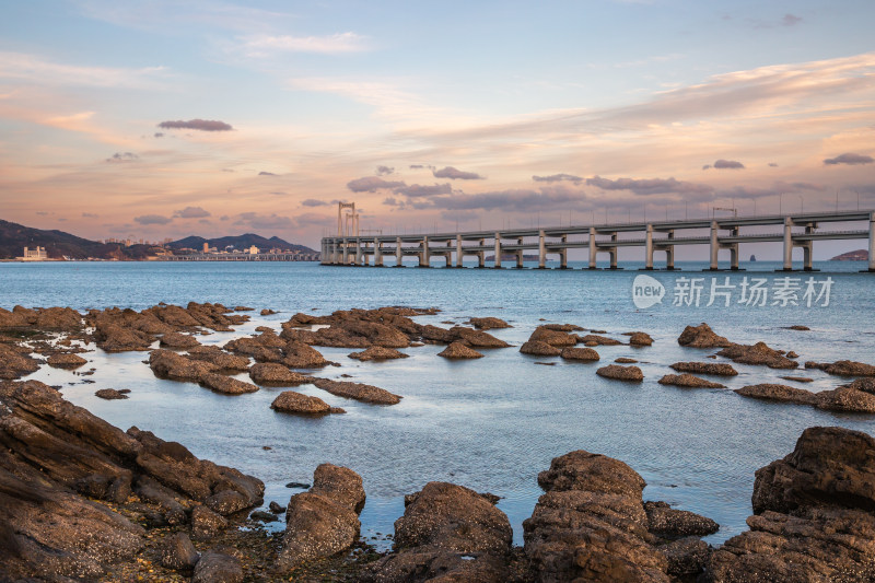 黄昏日落时的大连黑石礁公园海滩和跨海大桥