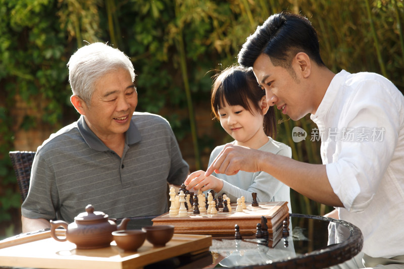 祖孙三代在庭院里下棋