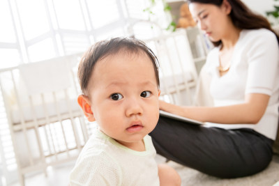 在家使用电脑的年轻妈妈和宝宝