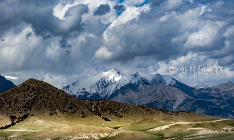 乌云下的雪山与多彩山峦风景