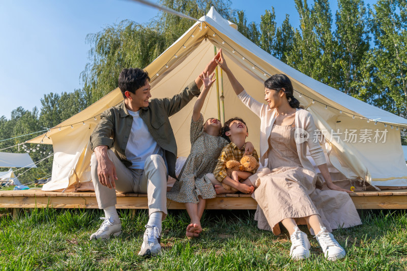 一家人坐在露营地的帐篷前
