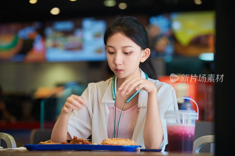 在商场快餐厅大吃特吃的中国可爱少女人像