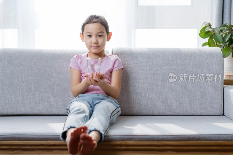 坐在沙发上喝水休息的中国女孩